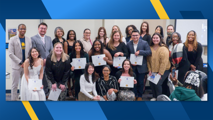 Three rows of people including counseling students and faculty pose with membership certificates.